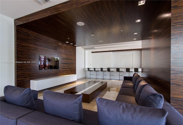 home theater room featuring light tile patterned floors and wood ceiling