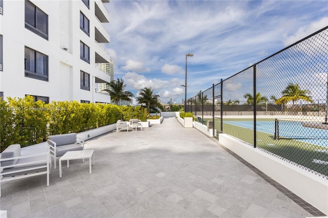 view of home's community featuring tennis court