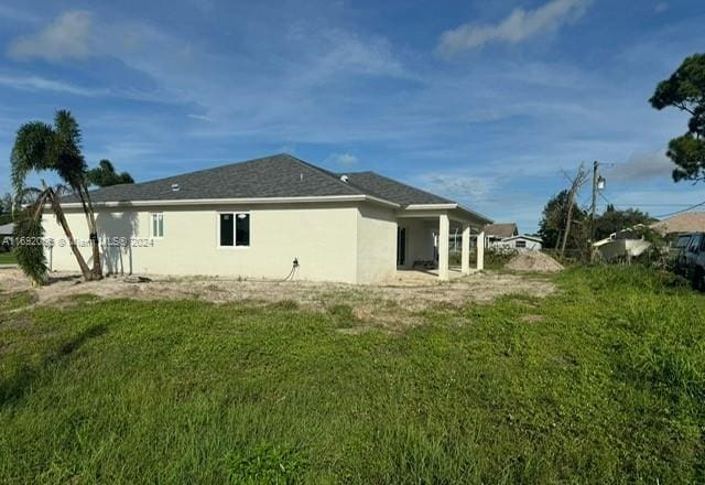 back of house with a lawn