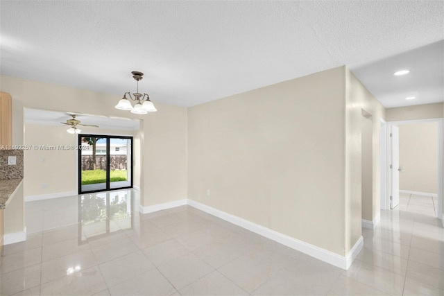 unfurnished room with ceiling fan with notable chandelier, a textured ceiling, and light tile patterned floors