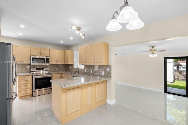 kitchen with kitchen peninsula, decorative backsplash, hanging light fixtures, light brown cabinets, and appliances with stainless steel finishes