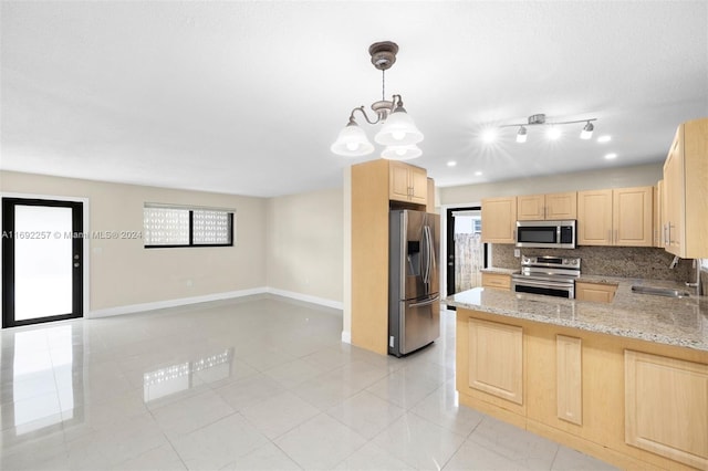 kitchen with sink, kitchen peninsula, appliances with stainless steel finishes, light brown cabinetry, and pendant lighting