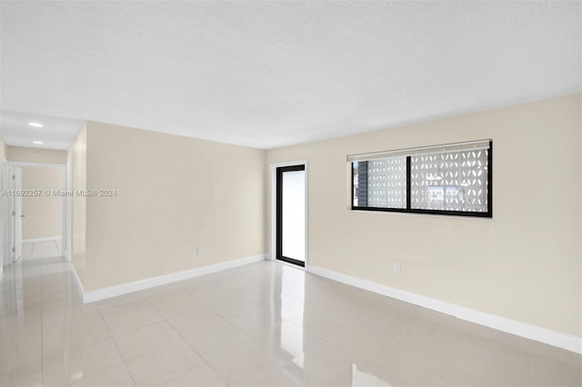 unfurnished room with a textured ceiling