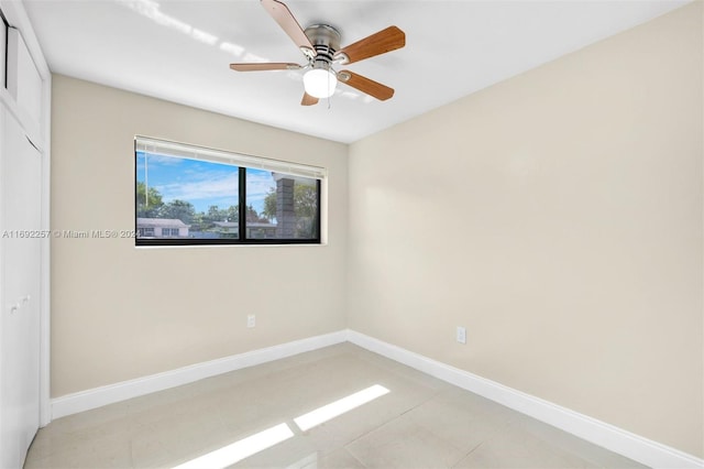 tiled spare room featuring ceiling fan