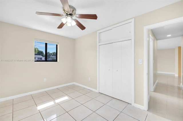 unfurnished bedroom featuring light tile patterned flooring, ceiling fan, and a closet