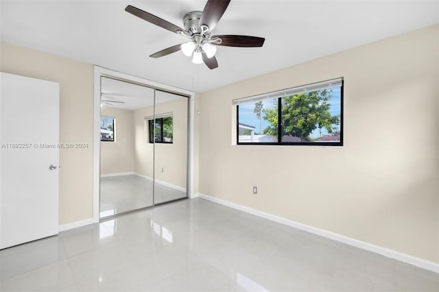 unfurnished bedroom featuring light tile patterned floors, ceiling fan, and a closet