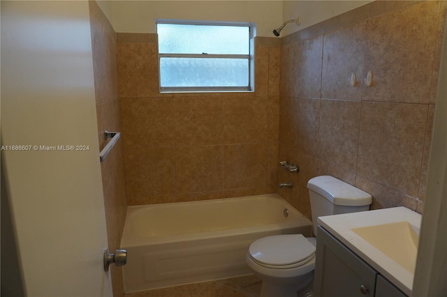 full bathroom featuring tile patterned floors, toilet, tile walls, tiled shower / bath, and vanity