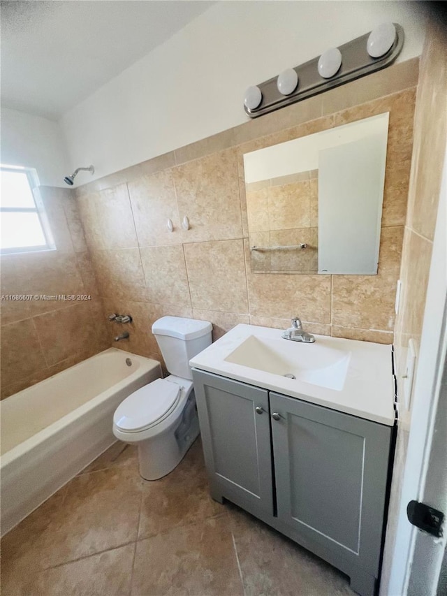 full bathroom featuring vanity, tile patterned floors, tile walls, and tiled shower / bath combo