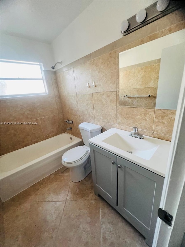 full bathroom featuring tile walls, vanity, tiled shower / bath combo, tile patterned flooring, and toilet