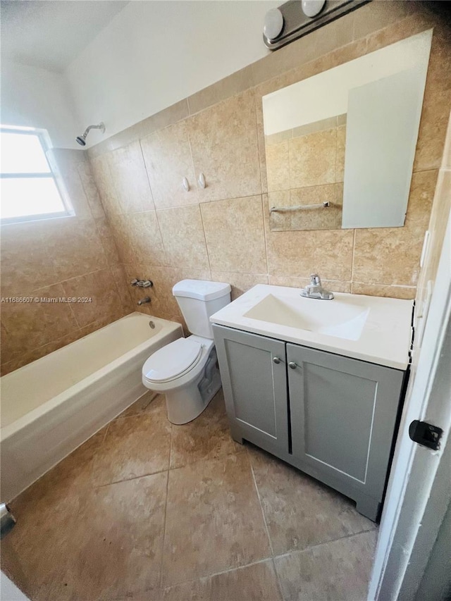 full bathroom featuring toilet, tile walls, tile patterned flooring, tiled shower / bath, and vanity