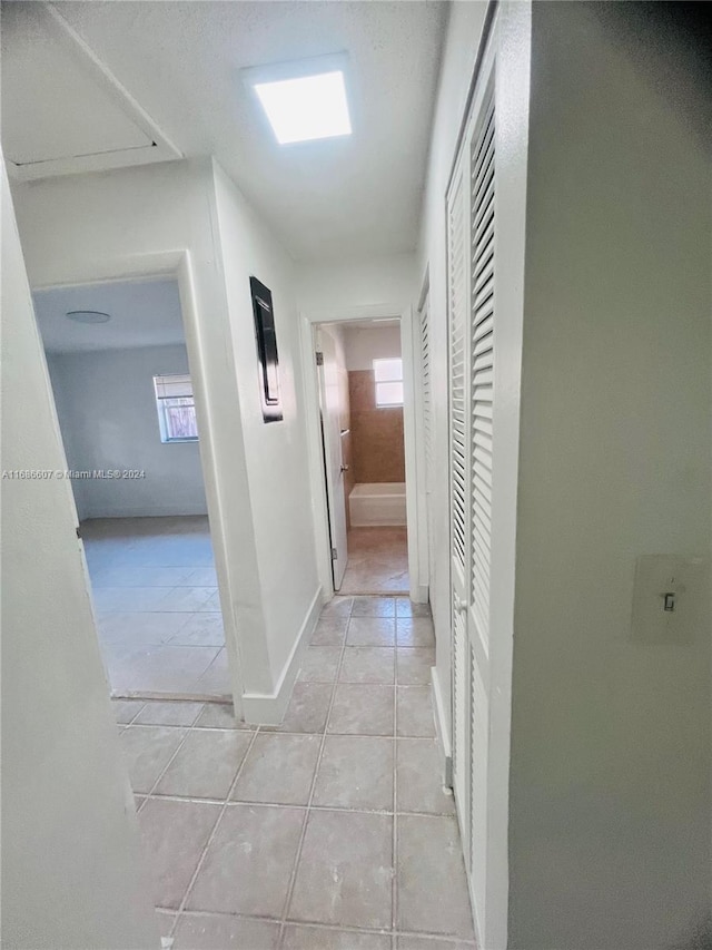 hall featuring light tile patterned floors