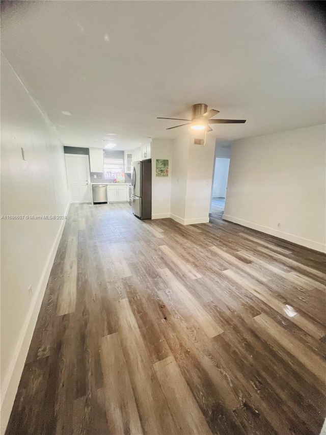 unfurnished living room with light wood-type flooring and ceiling fan