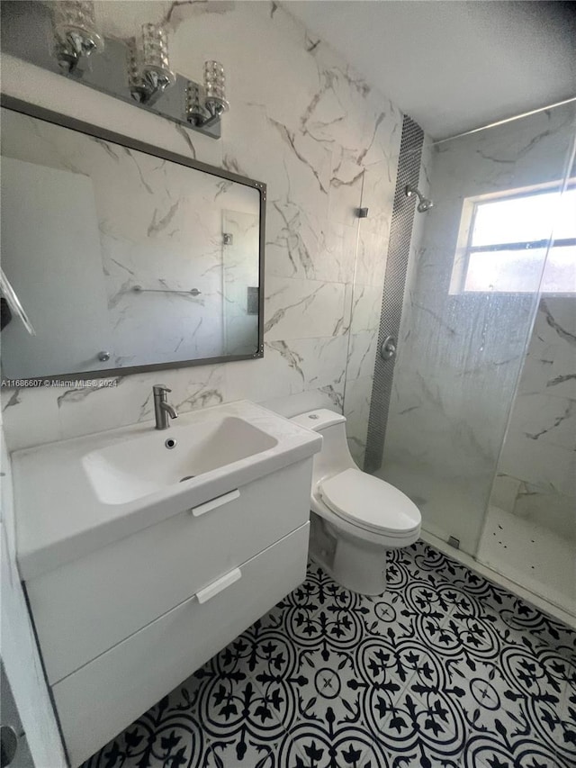 bathroom featuring tile walls, a tile shower, vanity, and toilet