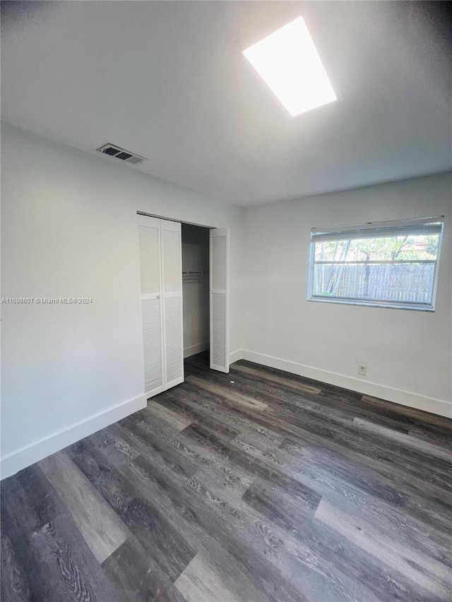 unfurnished bedroom with a closet and dark hardwood / wood-style flooring