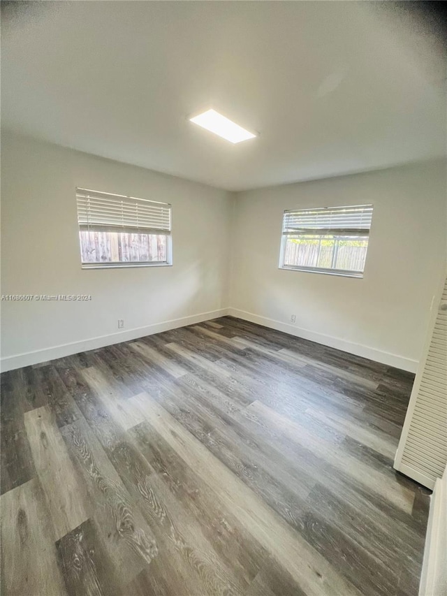 unfurnished room featuring dark hardwood / wood-style floors and plenty of natural light