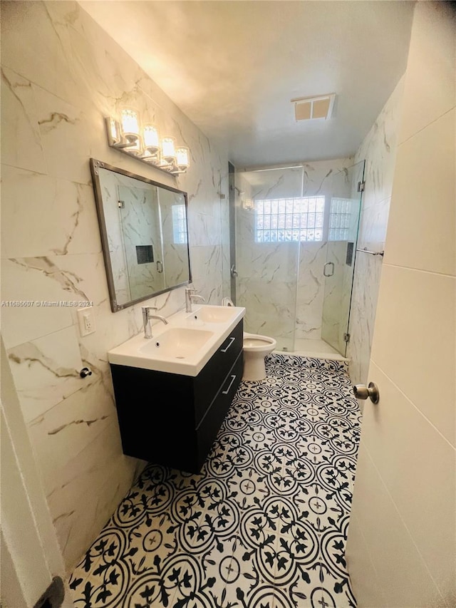 bathroom featuring a shower with shower door, vanity, toilet, and tile walls