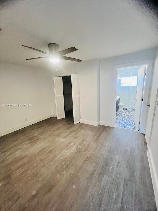 unfurnished bedroom with connected bathroom, hardwood / wood-style floors, and ceiling fan