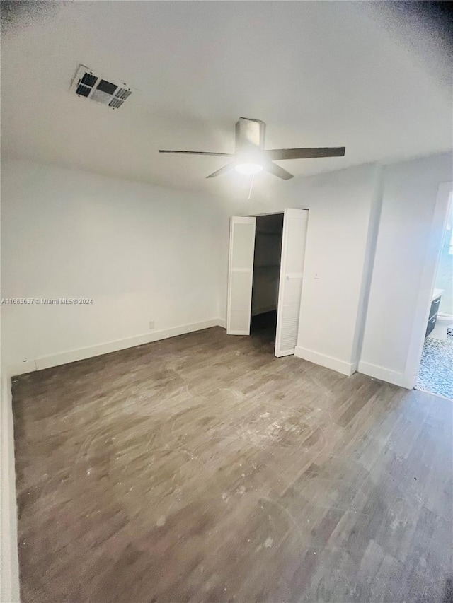 unfurnished bedroom with connected bathroom, hardwood / wood-style flooring, and ceiling fan