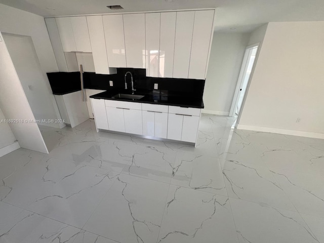 kitchen featuring sink and white cabinets