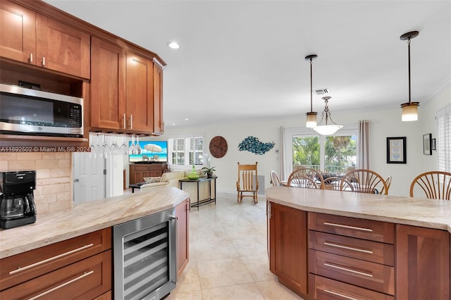 kitchen with backsplash, light tile patterned floors, light stone countertops, hanging light fixtures, and beverage cooler