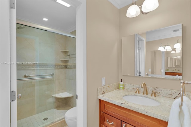 bathroom with an inviting chandelier, vanity, crown molding, a shower with shower door, and toilet