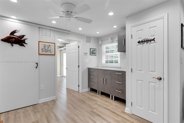 interior space featuring dark brown cabinetry, light hardwood / wood-style flooring, and ceiling fan