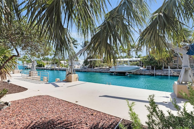 view of swimming pool featuring a water view and a boat dock