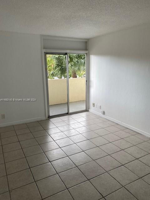 tiled spare room with a textured ceiling