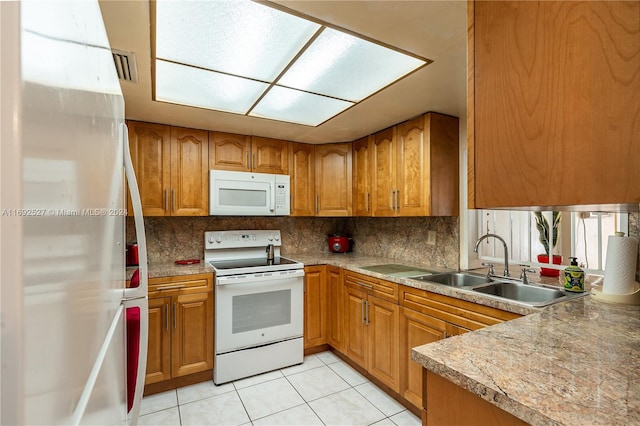 kitchen with sink, white appliances, backsplash, and light tile patterned floors