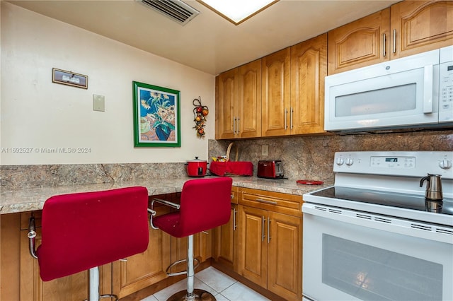 kitchen with white appliances, decorative backsplash, and light tile patterned floors