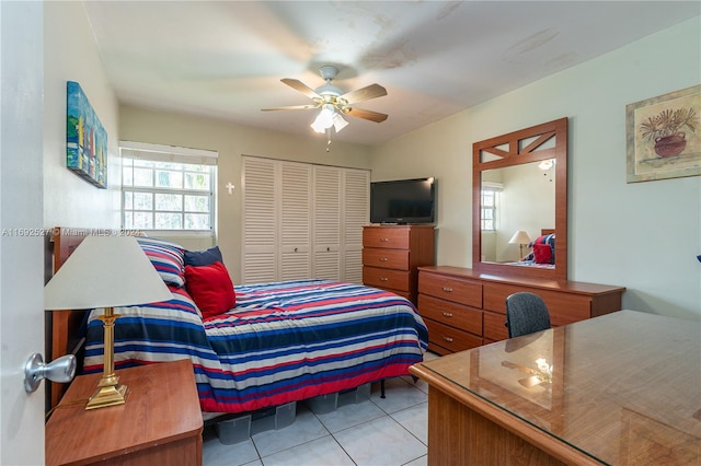 tiled bedroom featuring ceiling fan and a closet