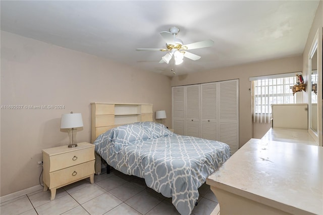 bedroom featuring light tile patterned floors, ceiling fan, and a closet