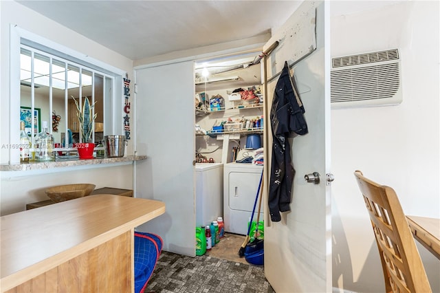 clothes washing area featuring a wall unit AC and washing machine and clothes dryer