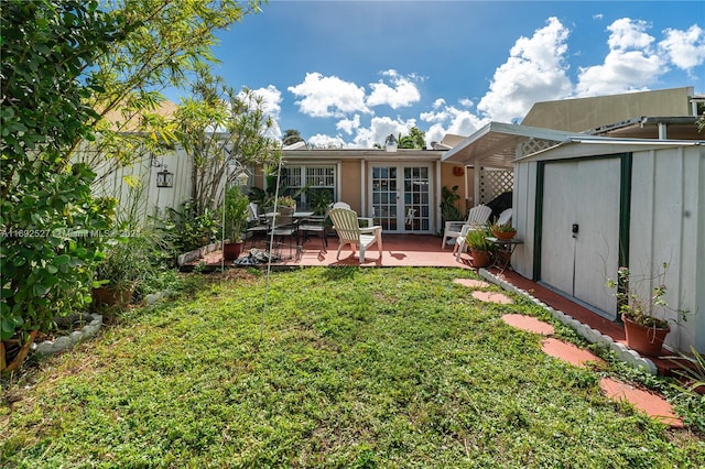 rear view of house with a lawn, a storage shed, french doors, and a patio area