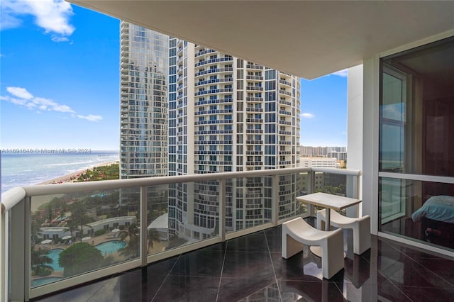 balcony featuring a water view and a beach view