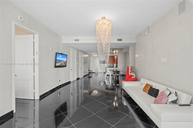 living room with dark tile patterned flooring and a chandelier