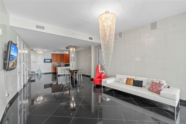 living room featuring dark tile patterned floors and a chandelier