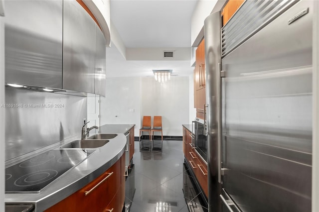 18101 Collins Ave Unit 1502, Sunny Isles Beach, FL 33160 - kitchen featuring built in refrigerator, modern cabinets, black electric stovetop, a sink, and dark tile patterned flooring