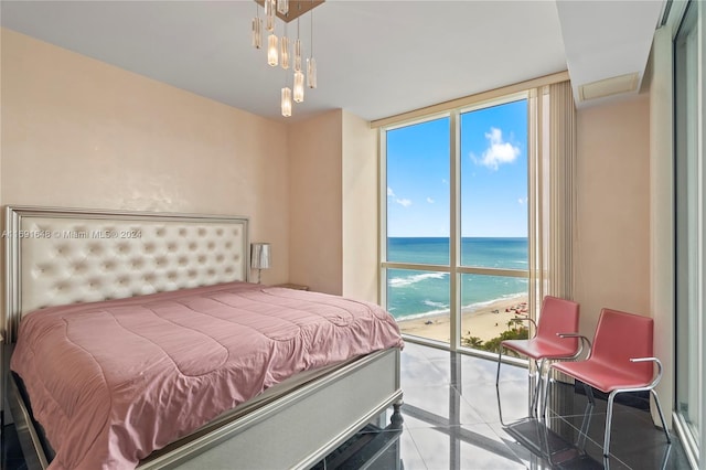 bedroom with a beach view, a water view, and expansive windows