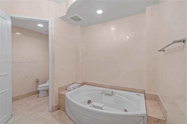 bathroom featuring a washtub, tile patterned flooring, and toilet