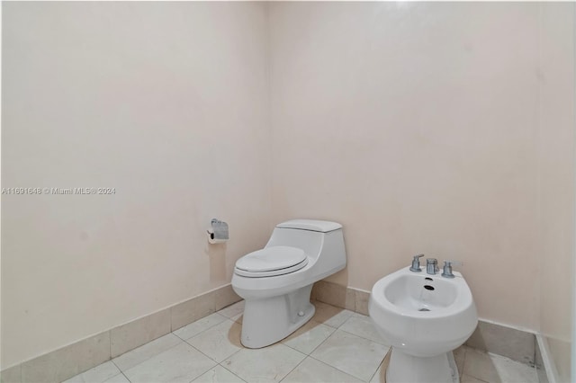 bathroom featuring tile patterned floors, toilet, and a bidet