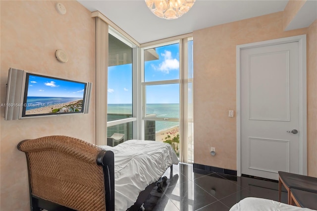 bedroom featuring a water view and dark tile patterned floors