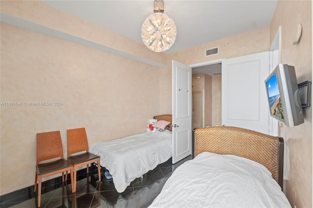 tiled bedroom featuring a chandelier