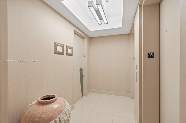 corridor with a skylight and light tile patterned flooring