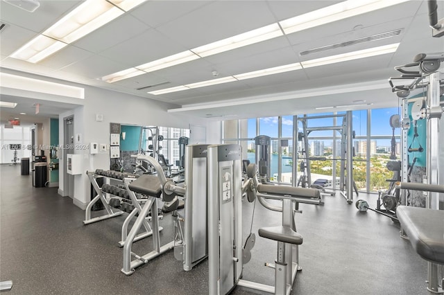 gym with a drop ceiling and a wealth of natural light