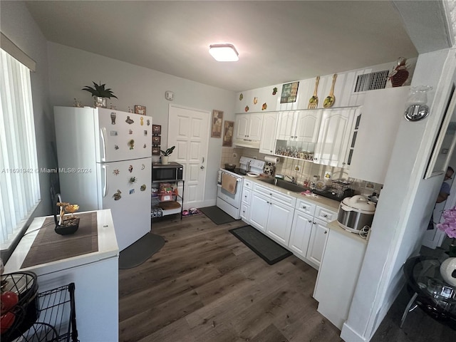 kitchen featuring white appliances, dark hardwood / wood-style floors, tasteful backsplash, a healthy amount of sunlight, and white cabinetry