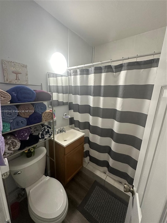 bathroom featuring a shower with shower curtain, vanity, wood-type flooring, and toilet