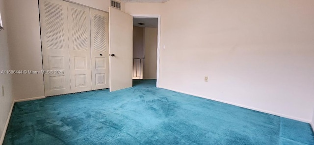 unfurnished bedroom featuring dark carpet and a closet