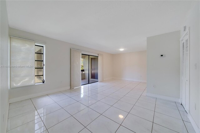 unfurnished bedroom with light tile patterned floors, multiple windows, and a closet