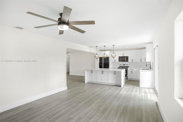 unfurnished living room with ceiling fan, sink, and light hardwood / wood-style floors